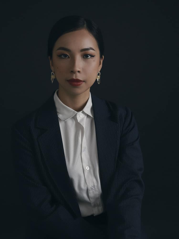 Retrato de Marina Okabe, mulher de cabelo preso, blazer escuro e camisa branca