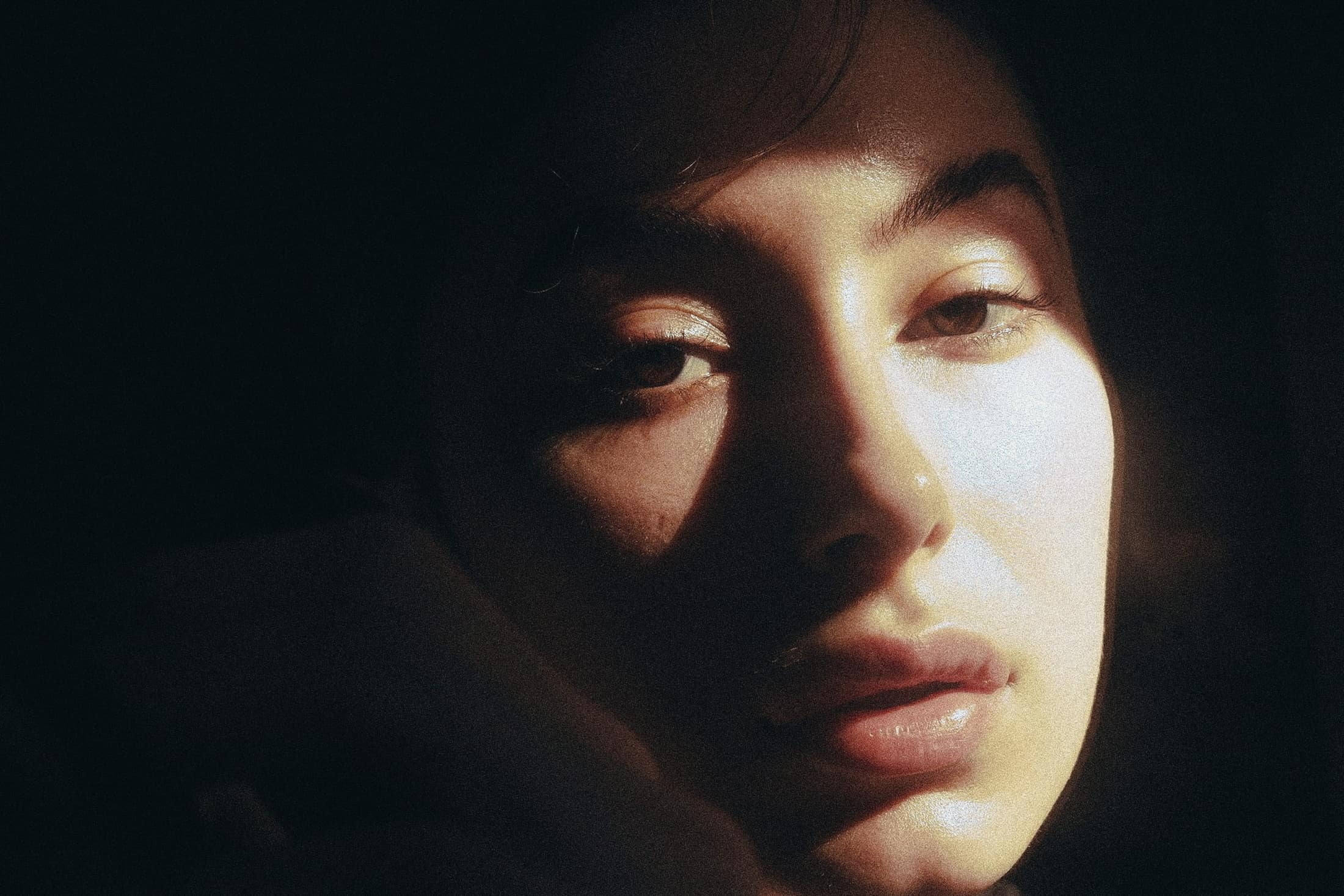 Close-up de rosto de mulher com luz quente atravessando os olhos